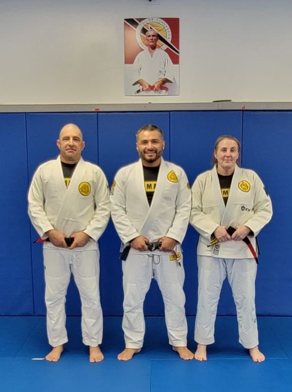 Mike and Erin standing with Professor Isaac Morales and their new black belts